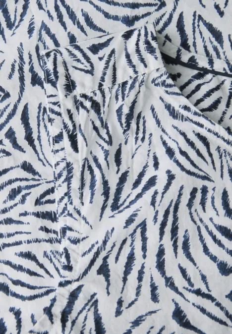 Weißer Stoff mit blauem Zebrastreifenmuster und einer Tasche.